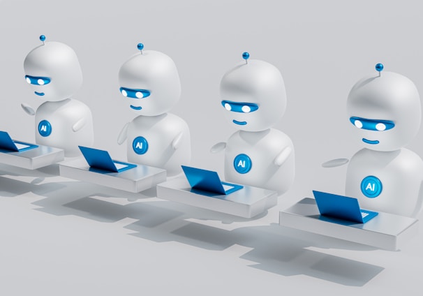 a group of white robots sitting on top of laptops