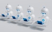 a group of white robots sitting on top of laptops