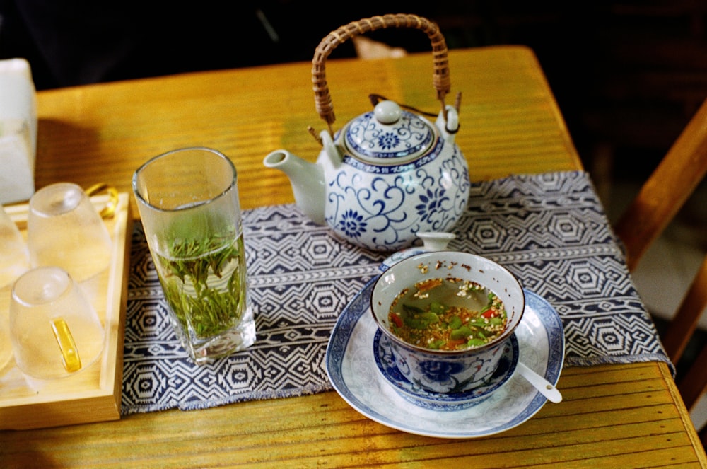 a table with a tea pot and a cup of soup