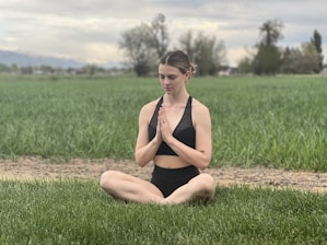 An athlete meditating calmly on a quiet field as the sun sets, embodying mental strength and focus.