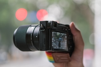 A black and red camera lens focused on a street scene showing public services in action.