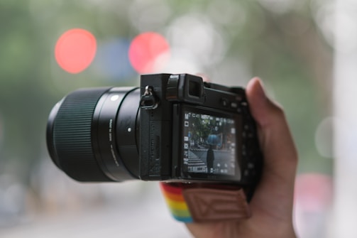 A black and red camera lens focused on a street scene showing public services in action.