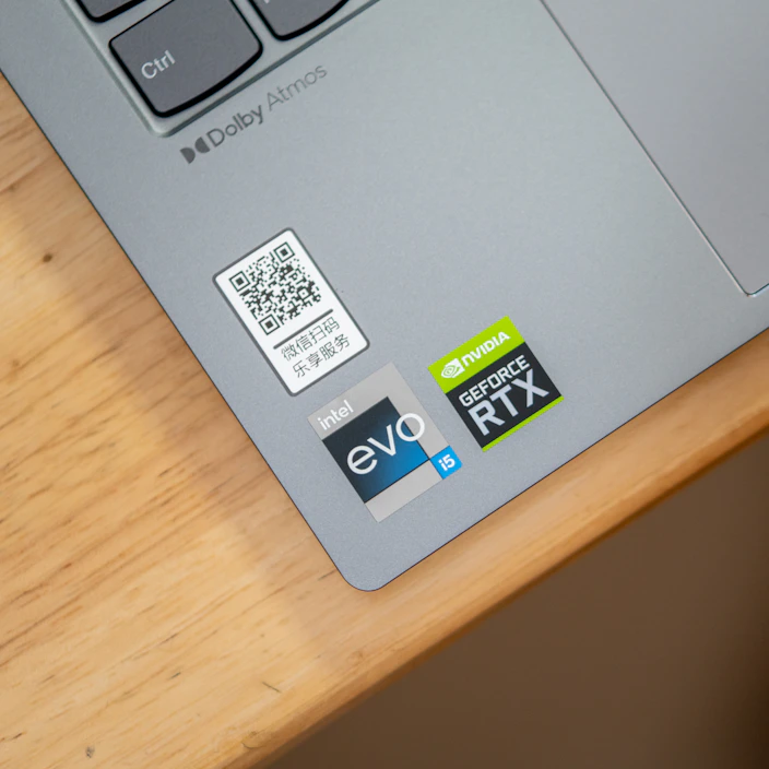 Close-up of various colorful QR code stickers on a laptop cover