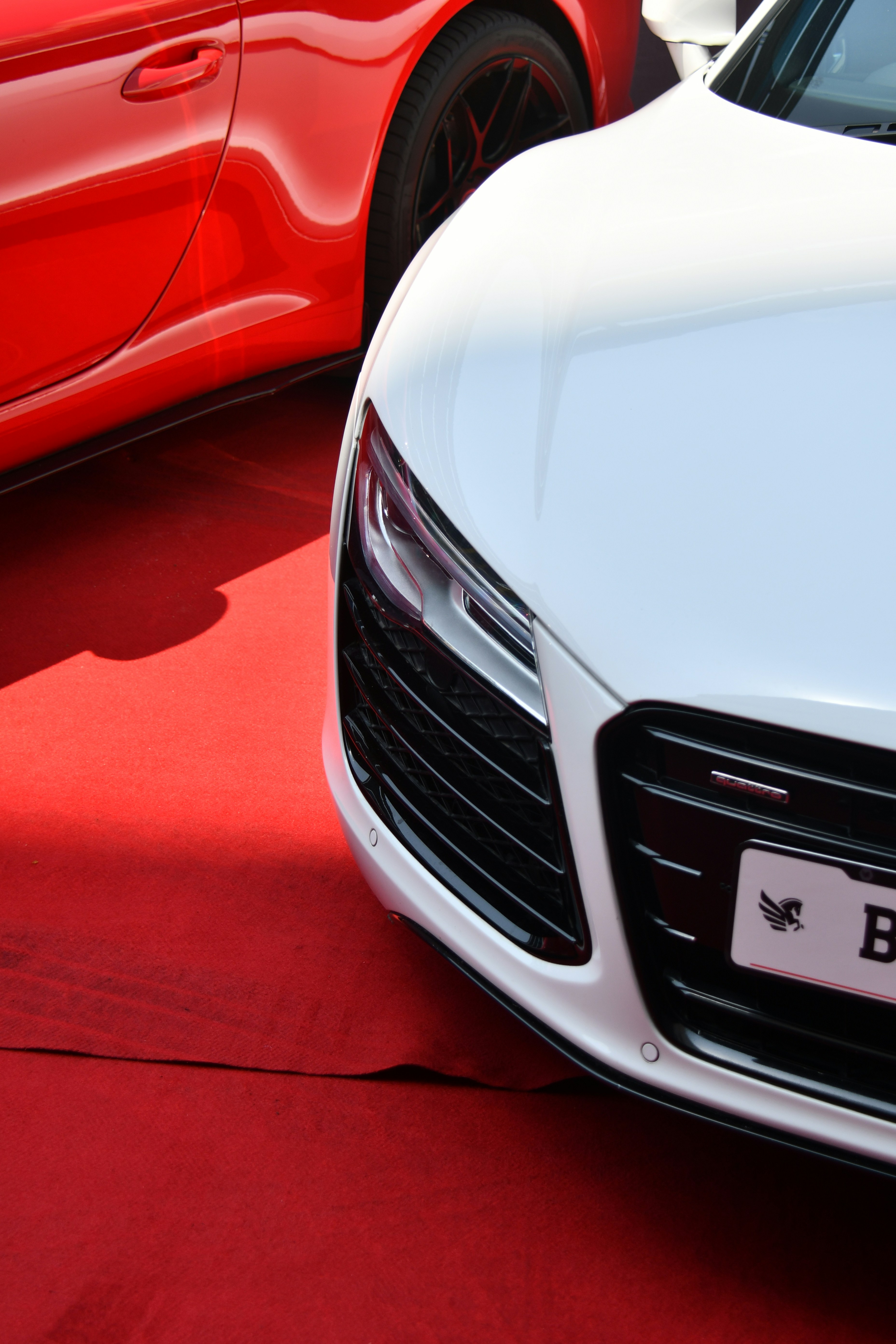 a white car parked next to a red car