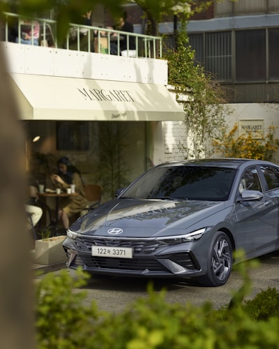 A sleek Hyundai car parked in front of a modern dealership building in Indonesia.