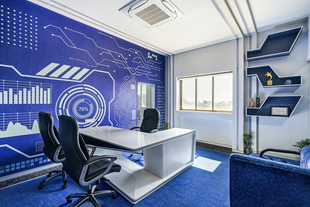 a room with a blue wall and a white desk