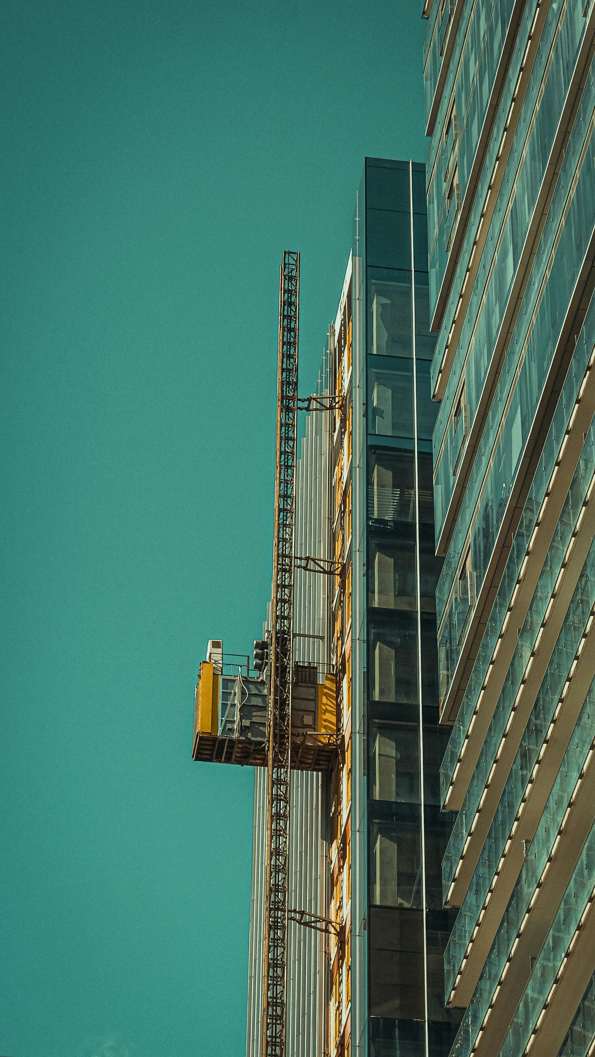 Foto zum Thema Ein kran ist an der seite eines hohen gebaudes ...