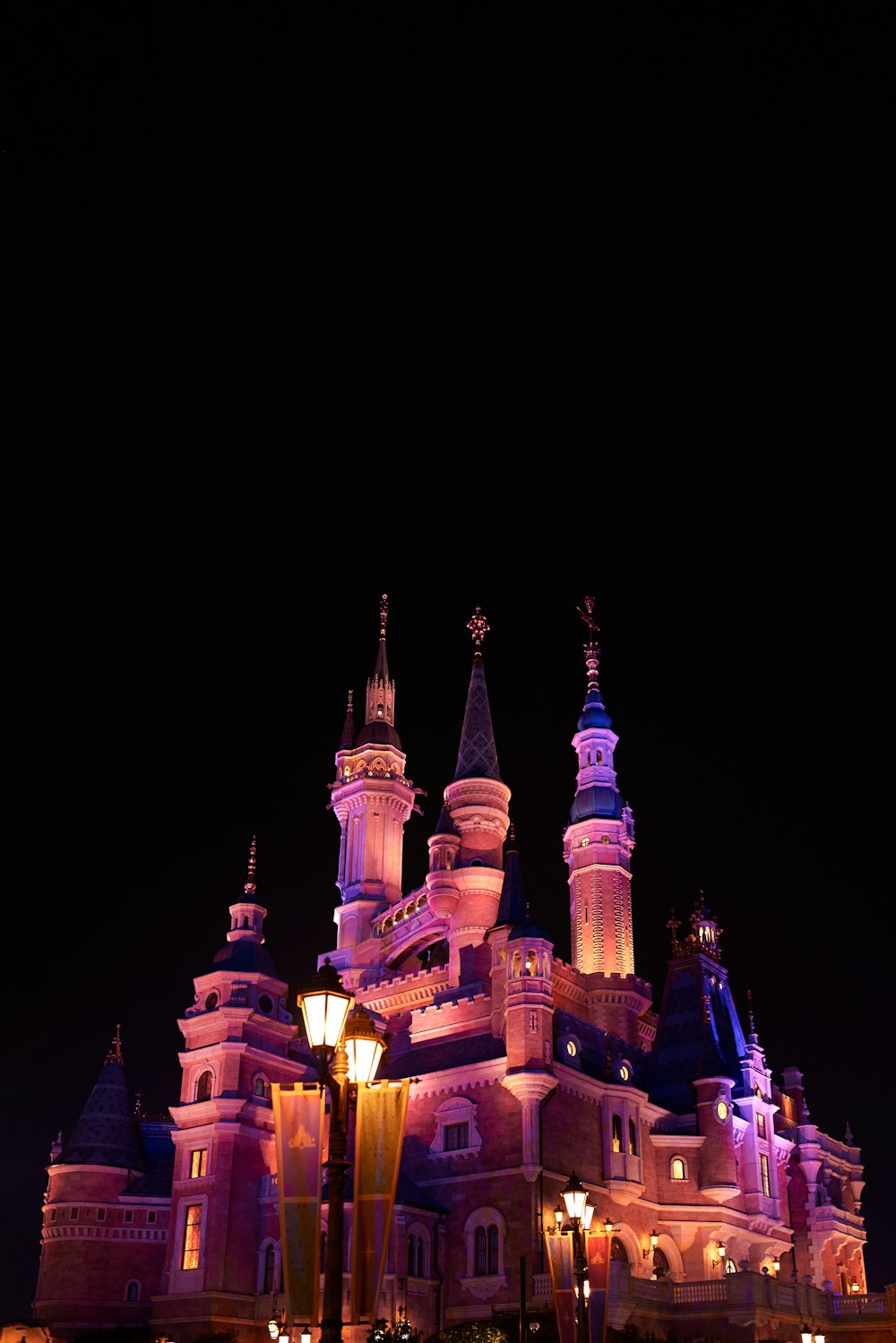 a castle lit up at night with a street light in front of it