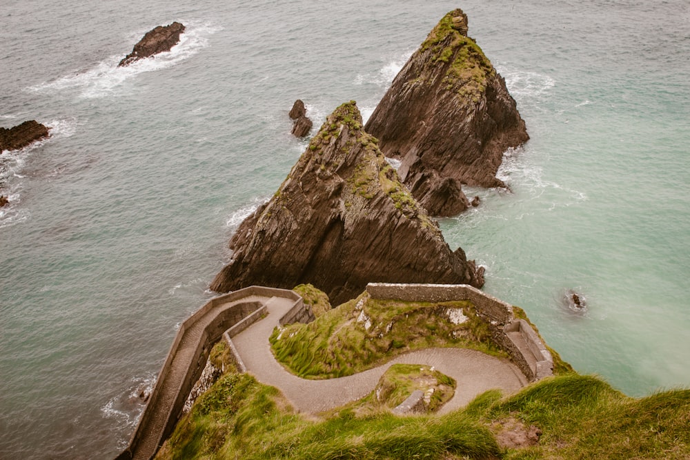 an aerial view of a path leading to the ocean