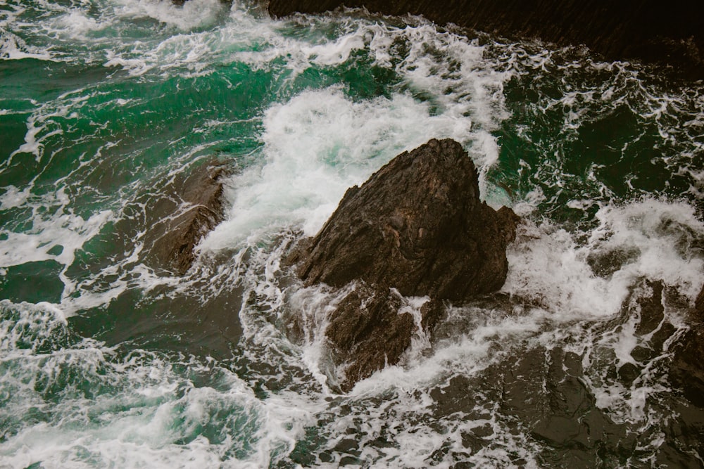 ein großer Felsen in der Mitte eines Gewässers