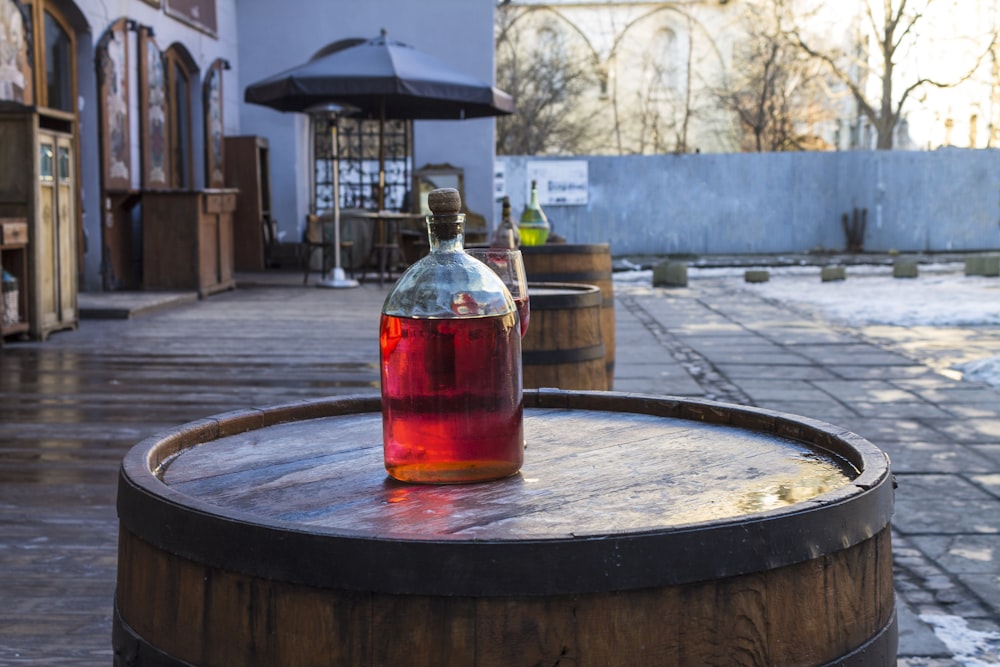 a bottle of wine sitting on top of a barrel