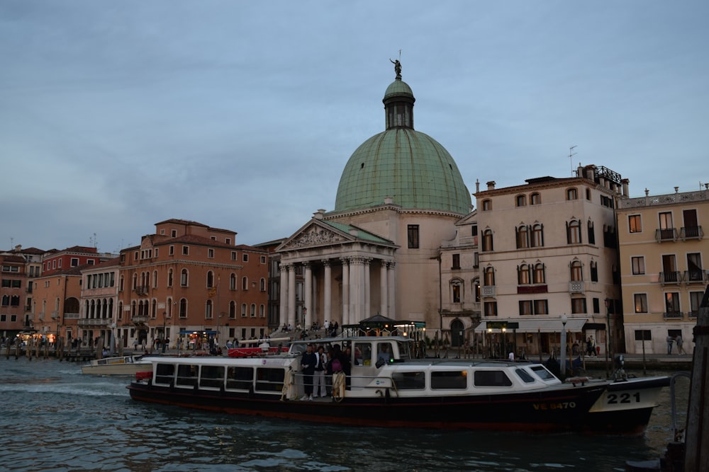 a boat traveling down a river next to tall buildings