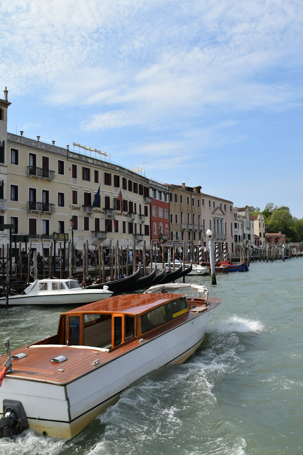 a boat traveling down a river next to tall buildings