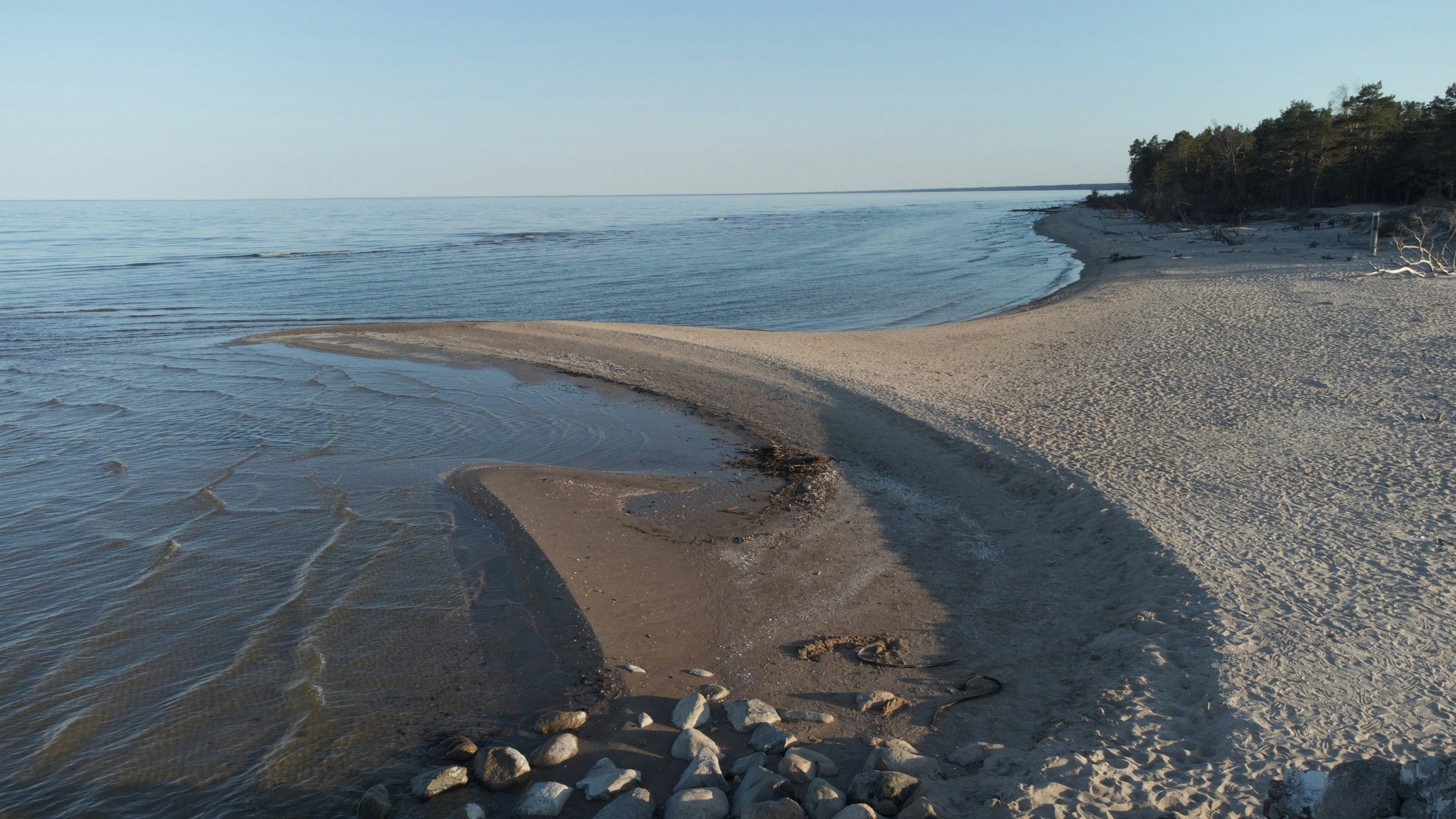 a sandy beach next to a body of water