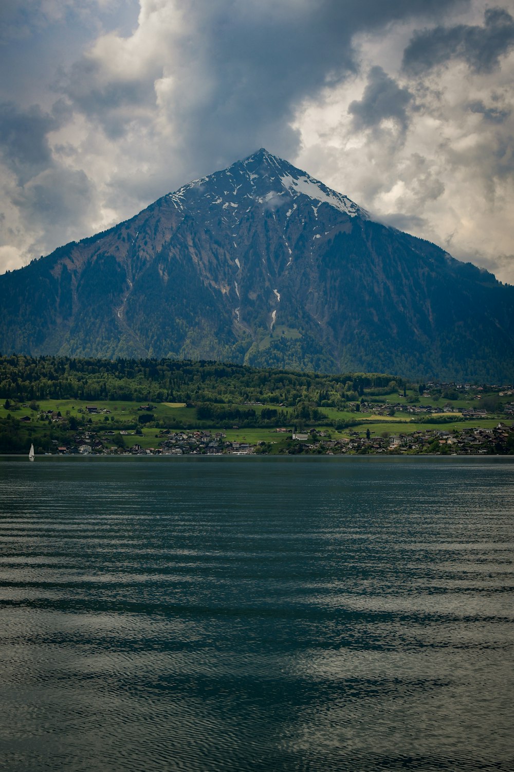 a large mountain is in the distance with a body of water in front of it