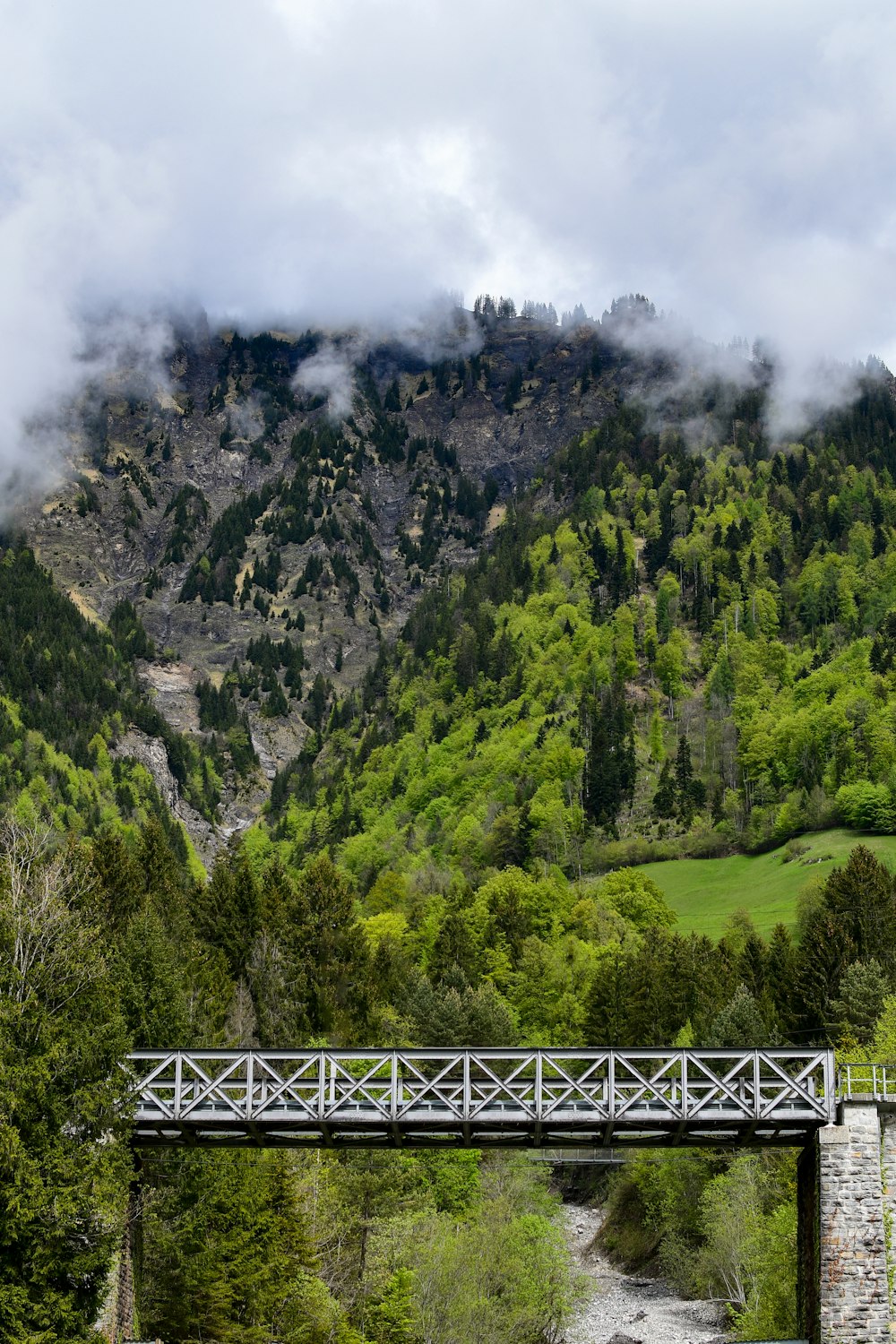 a bridge over a river with a mountain in the background