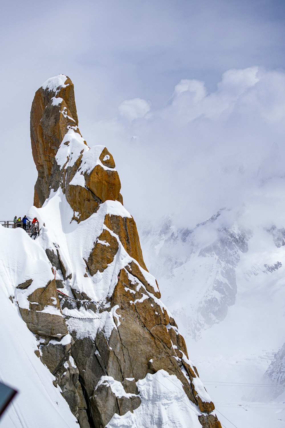 a group of people climbing up the side of a snow covered mountain