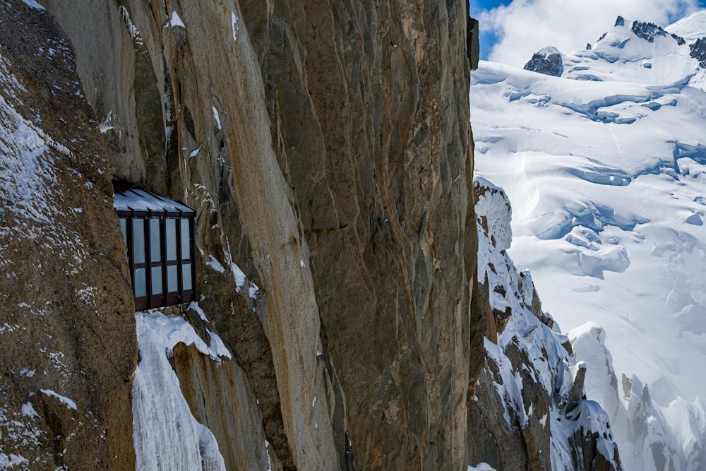 a window in the side of a snowy mountain