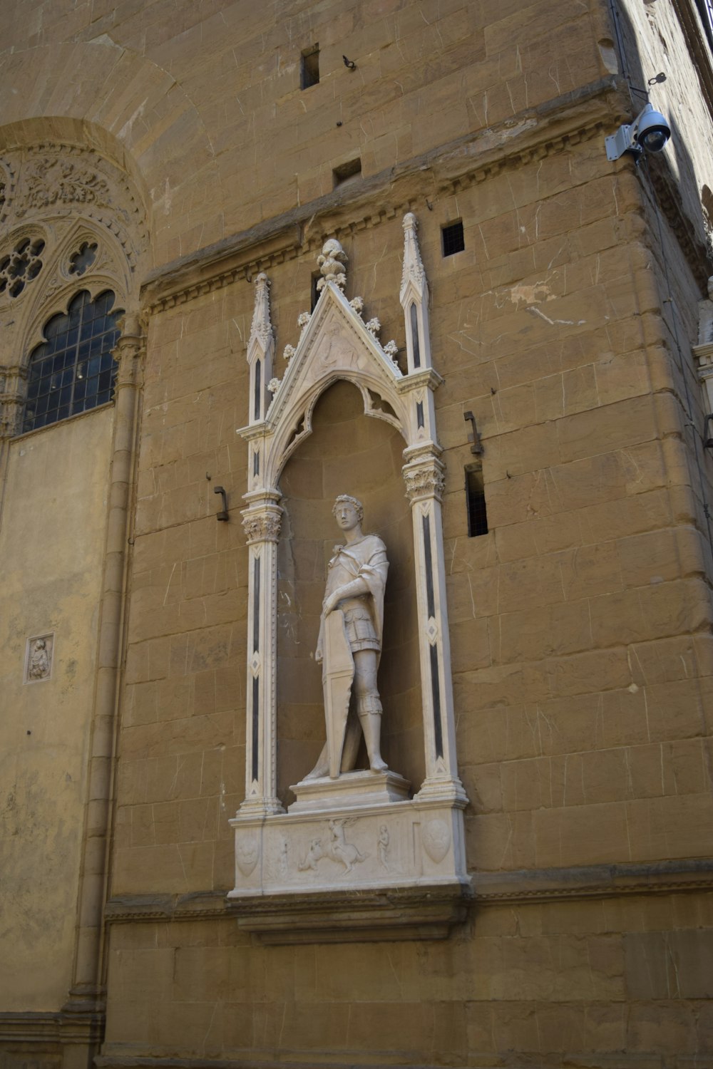 a statue of a man standing next to a tall building