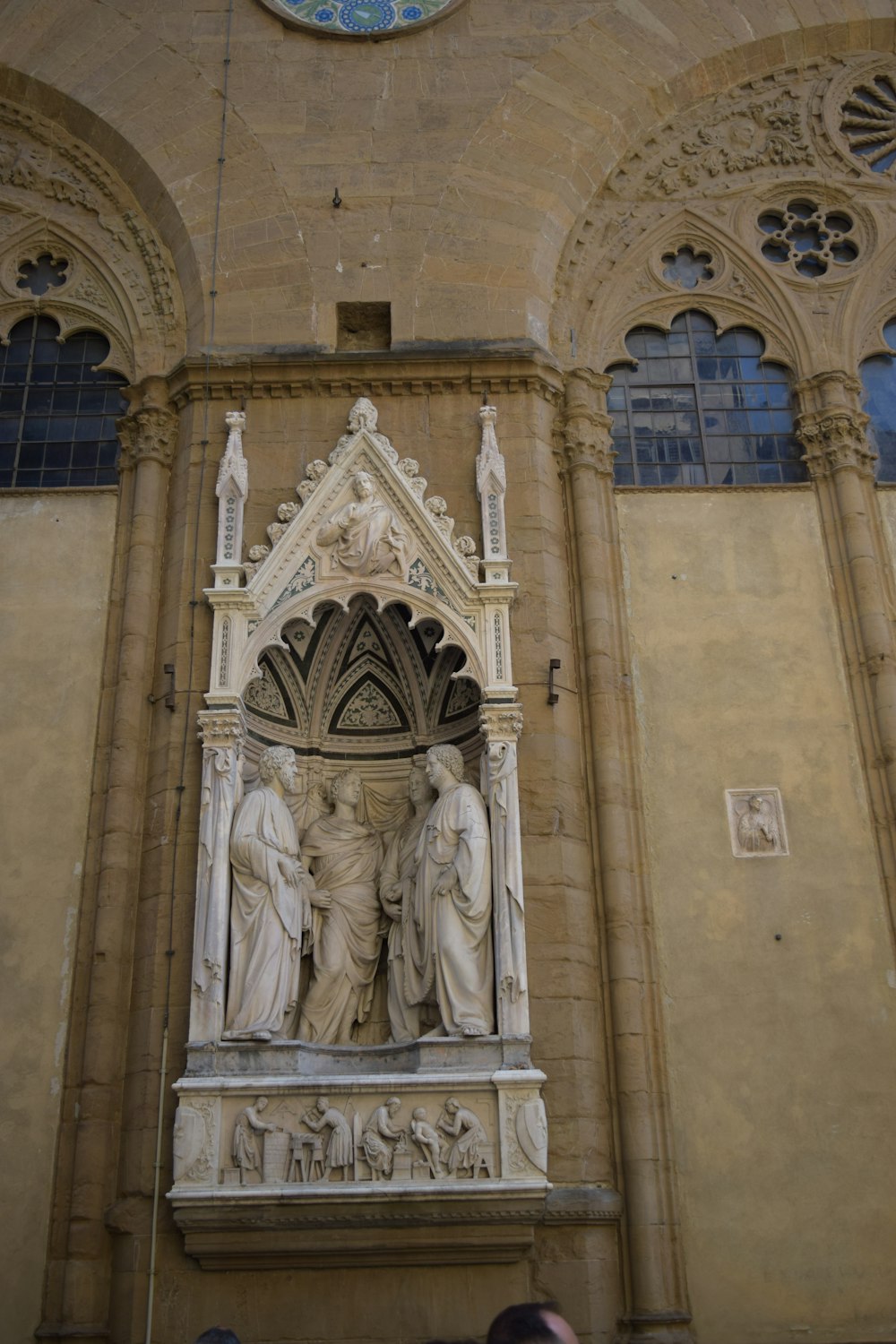 a statue in front of a building with a clock above it