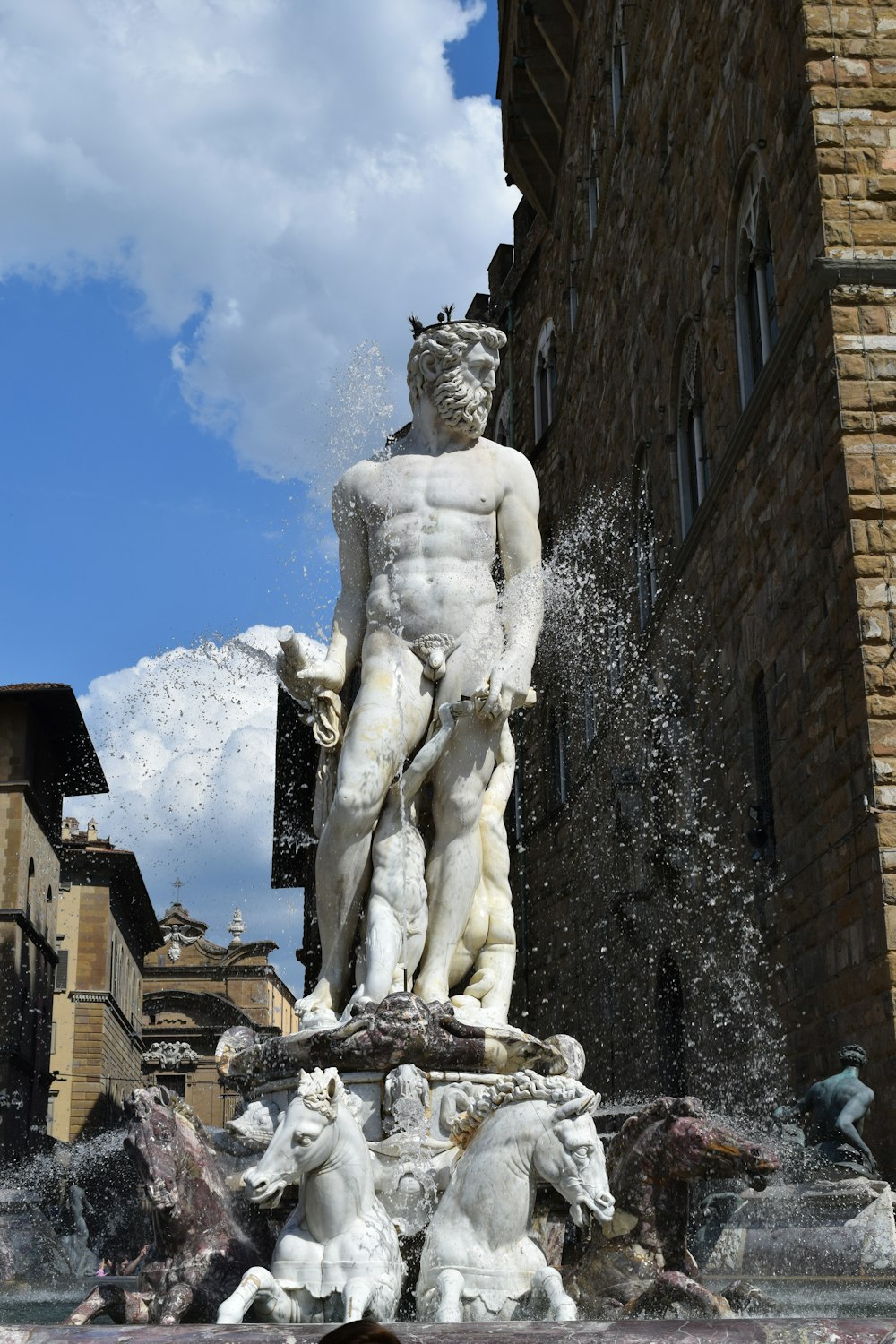 une statue d’un homme debout à côté d’un bâtiment