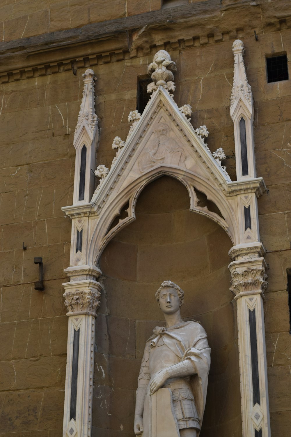 uma estátua de um homem em pé na frente de um edifício