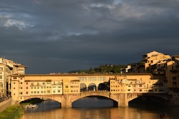 a bridge over a body of water under a cloudy sky