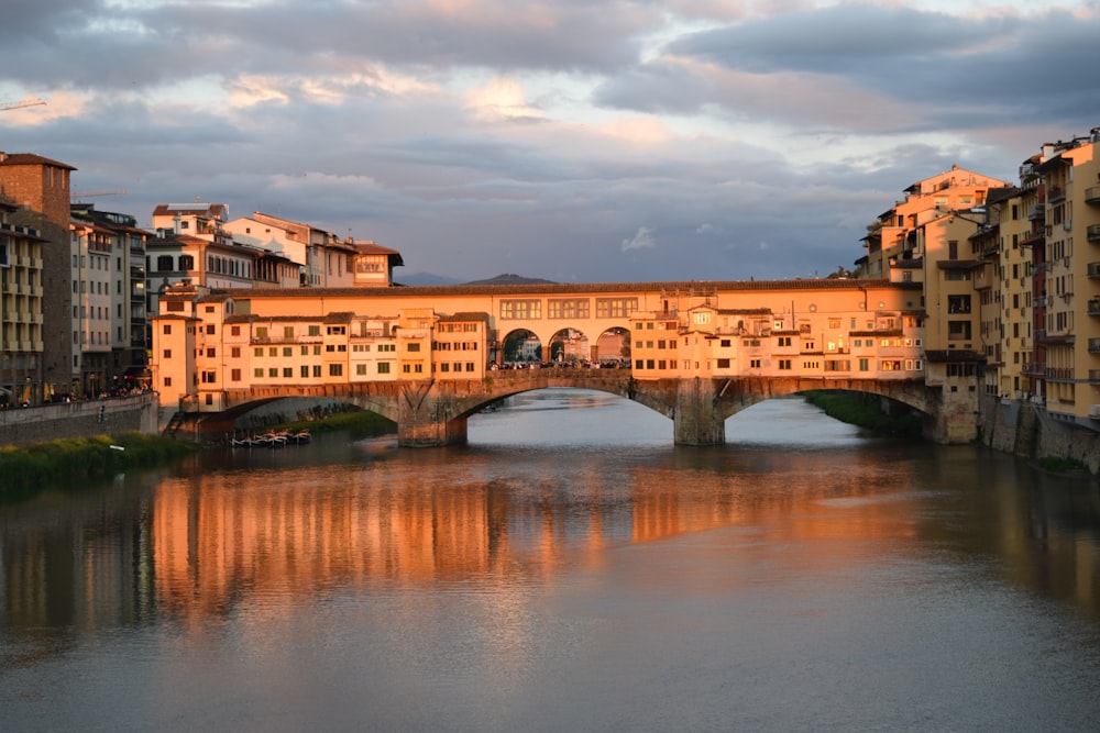 a bridge over a body of water with buildings in the background