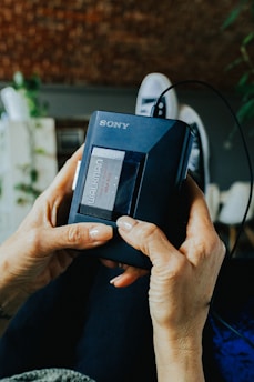 a woman holding a Sony Walkman in her hands