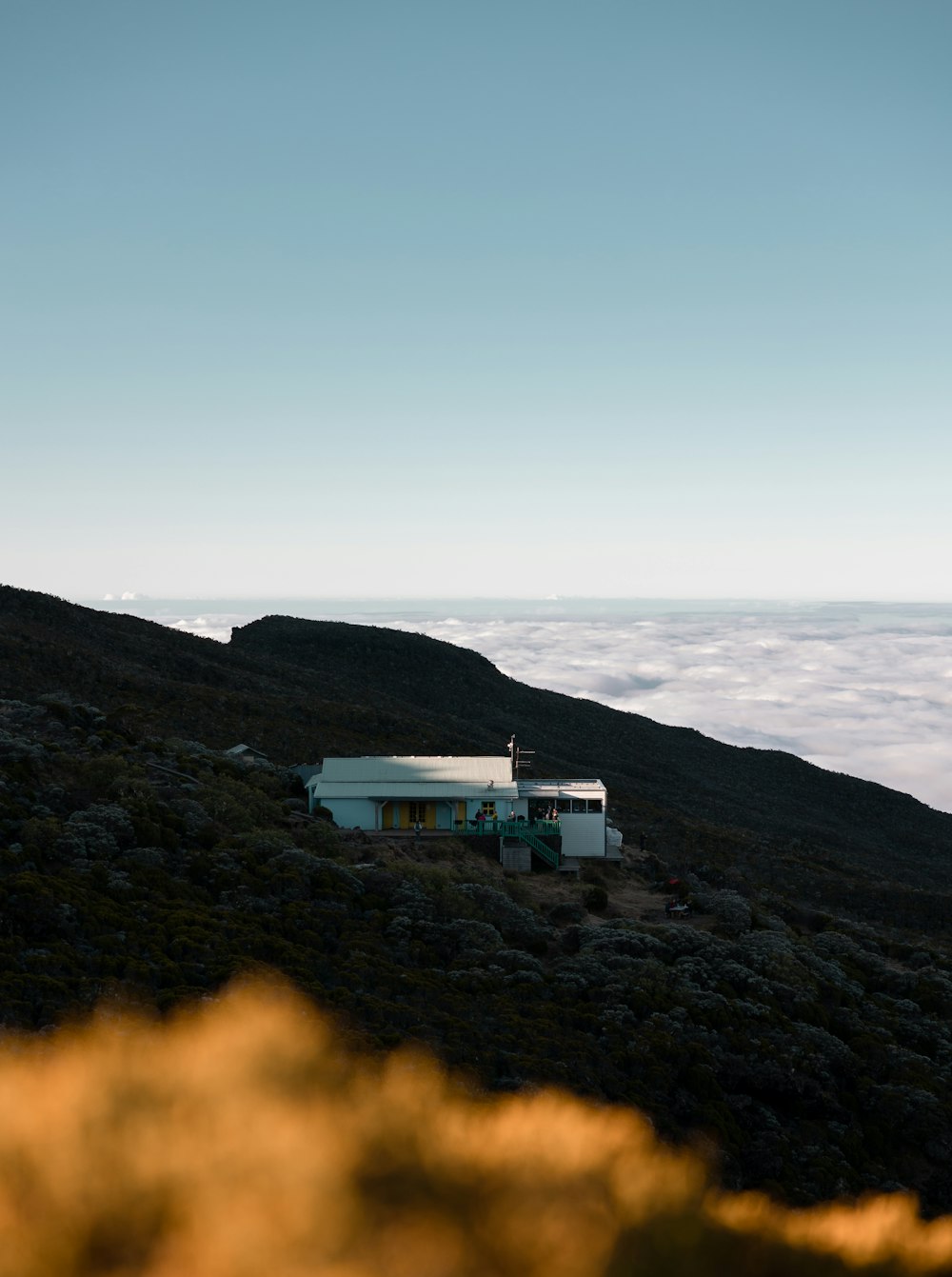 Una casa su una collina sopra le nuvole