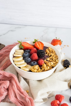 a bowl of fruit and cereal on a towel
