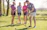 A group of friends enjoying a game of lawn bowling on a sunny day.