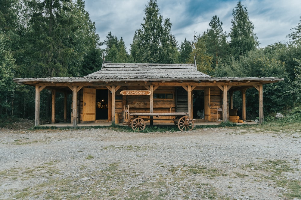 a small wooden building with a wagon in front of it