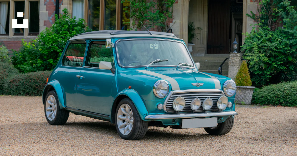 A small blue car parked in front of a building photo – Free Blue mini ...