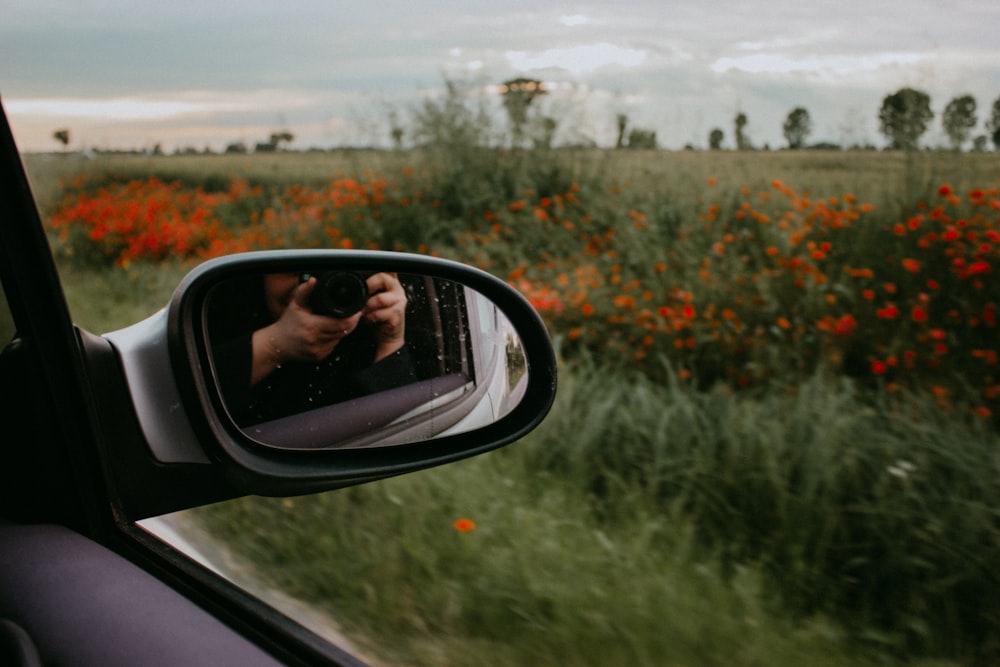 a person's reflection in the side mirror of a car