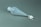 A translucent plastic separatory funnel with a conical shape lying on a grey surface. It has a screw cap on the top, a stopcock valve mechanism at the bottom, and a small nozzle extending from the valve.