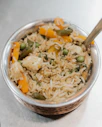 a bowl filled with rice and vegetables on top of a table