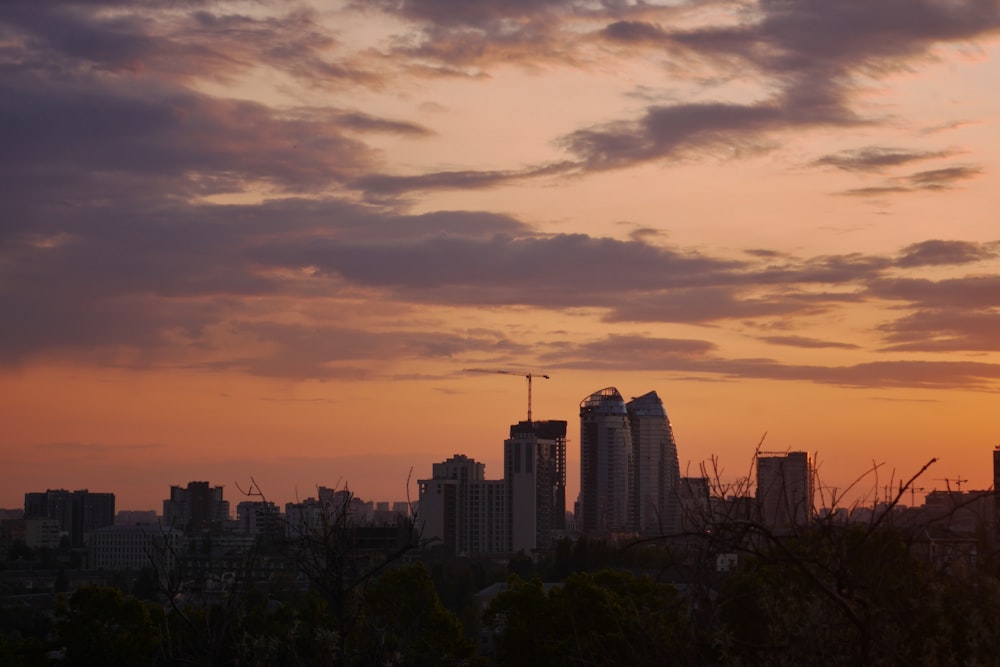 a sunset view of a city with tall buildings