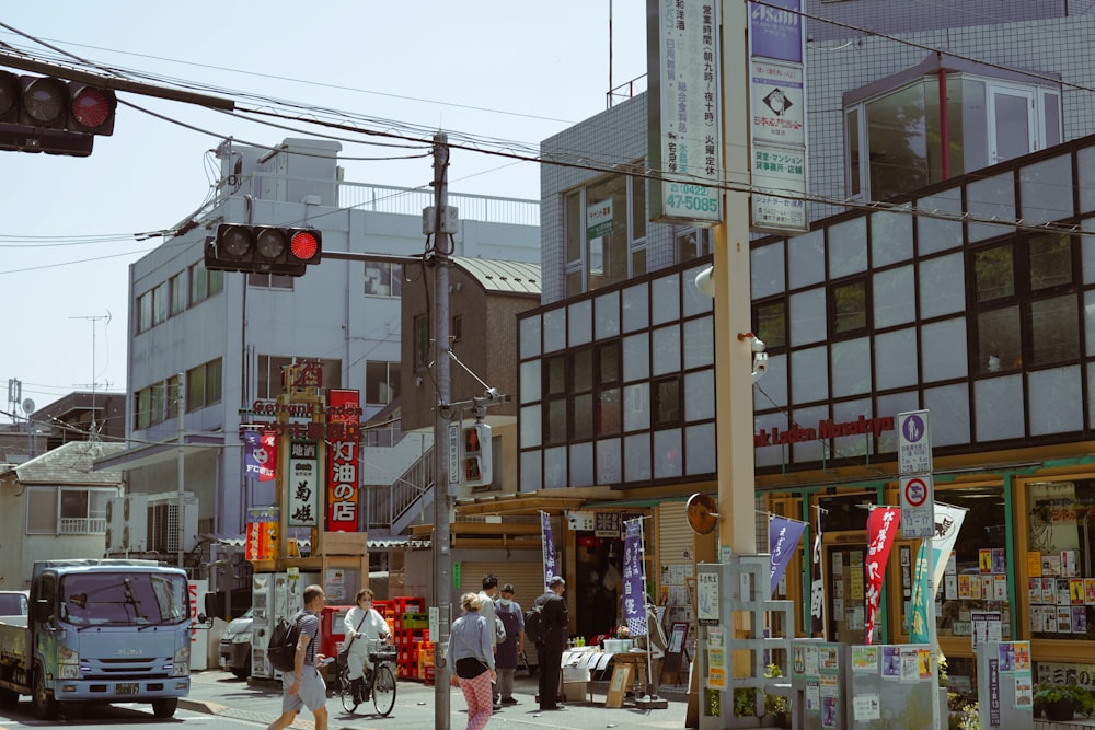 a group of people walking down a street next to tall buildings