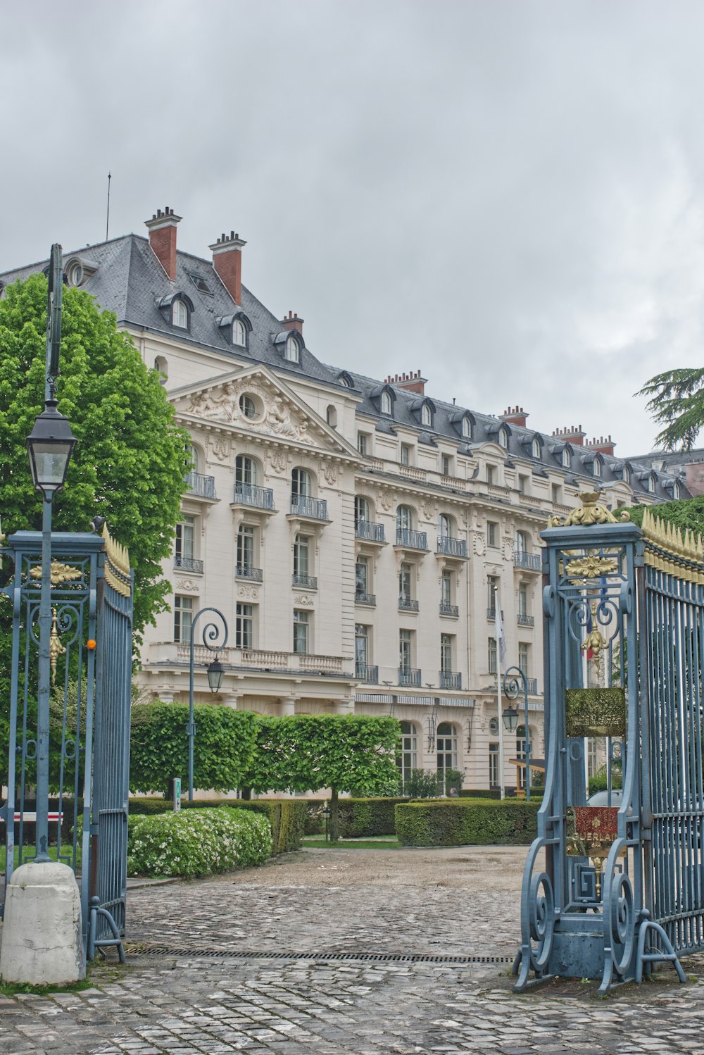 a blue gate in front of a large building