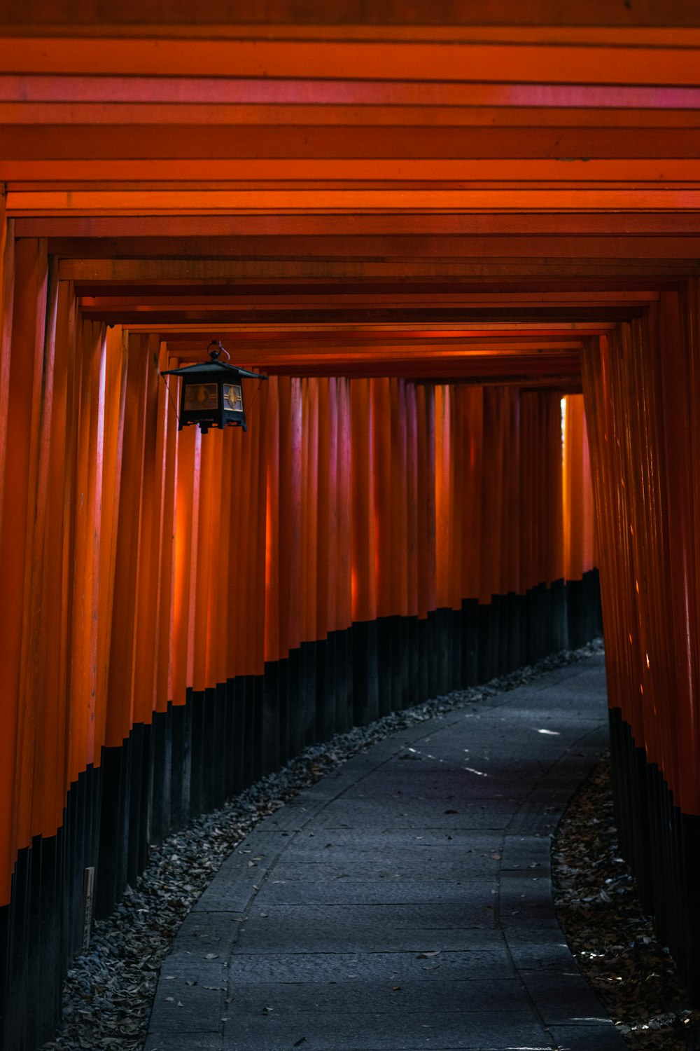 a walkway lined with red columns and lights