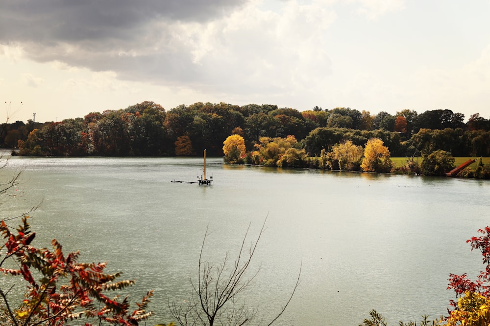 a sailboat on a lake surrounded by trees