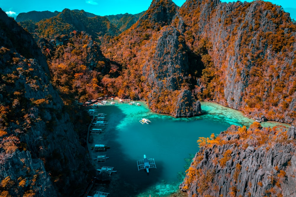 a group of boats floating on top of a lake surrounded by mountains