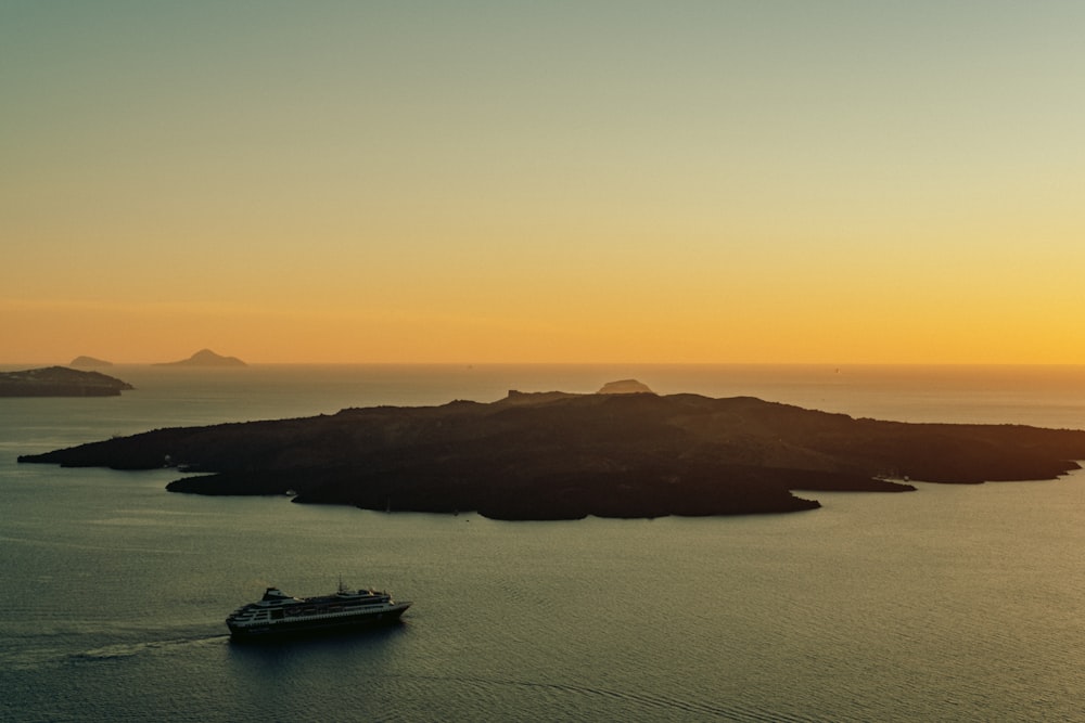 a cruise ship in the ocean at sunset