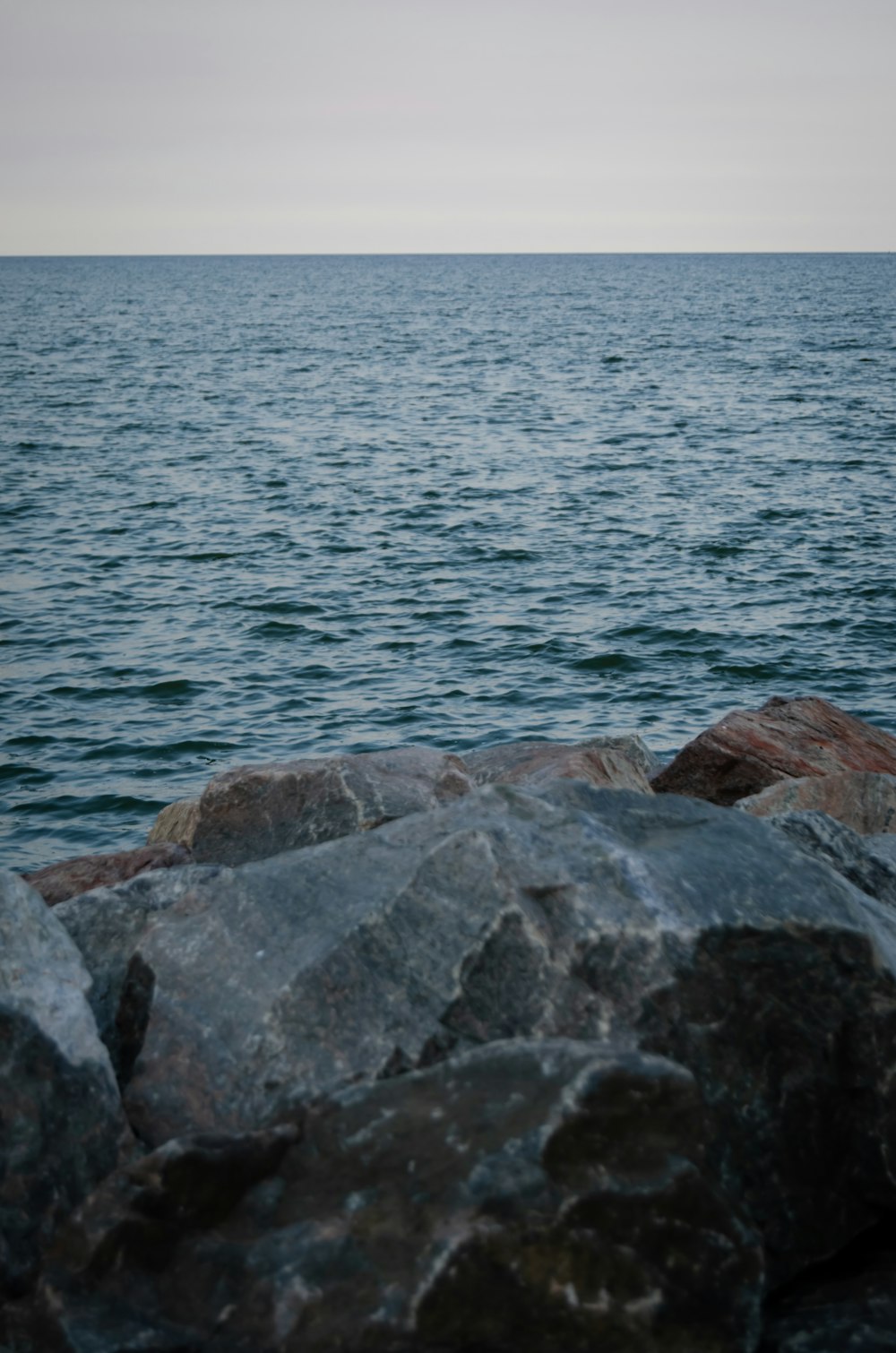 a large body of water sitting next to a rocky shore