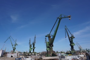 A panoramic view of a shipbuilding yard with cranes and vessels.