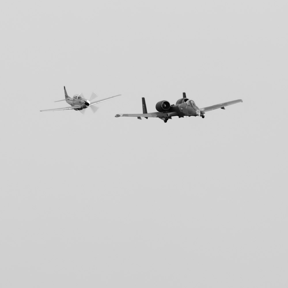 Zwei Flugzeuge, die an einem nebligen Tag am Himmel fliegen