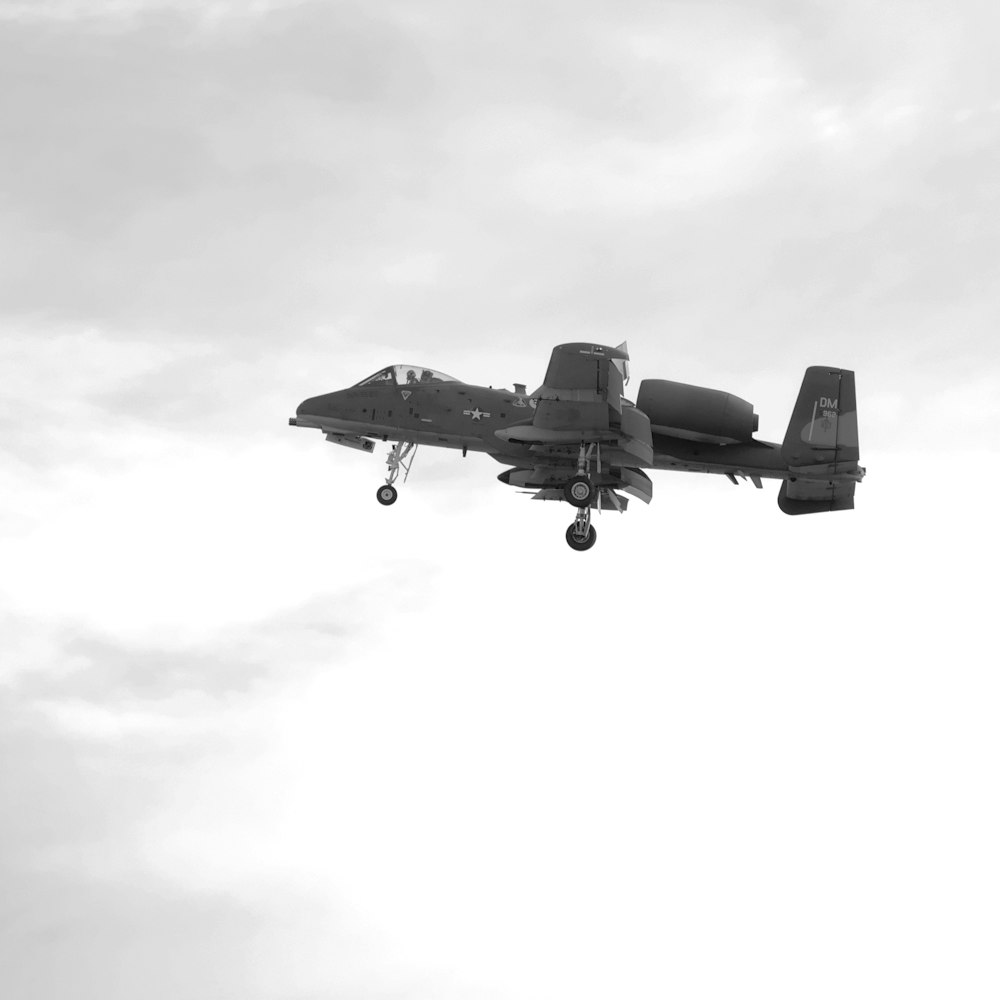 a fighter jet flying through a cloudy sky