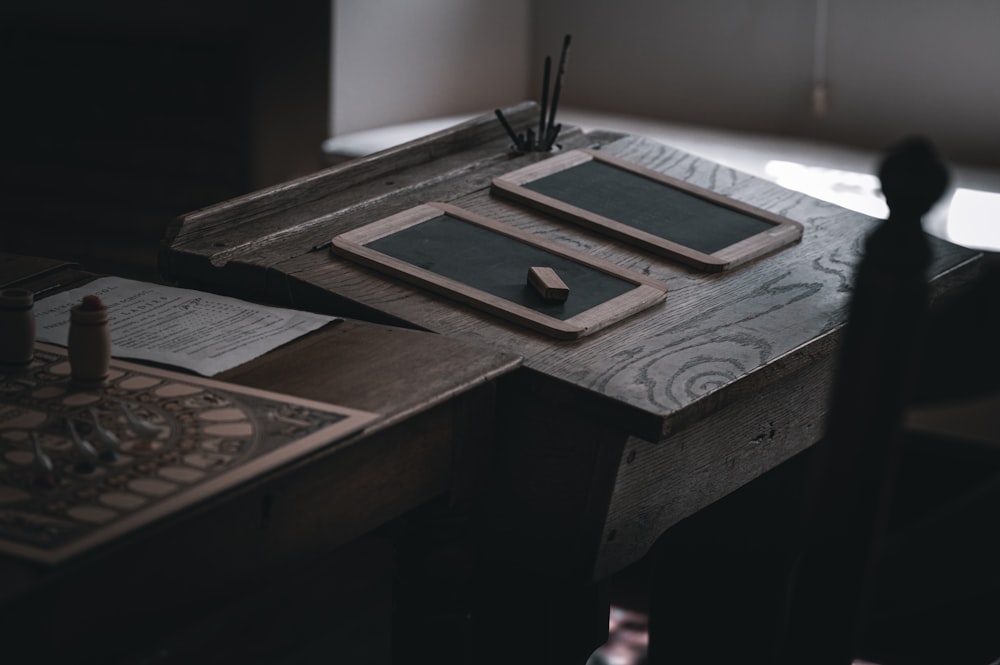 a wooden desk with a tablet and pen on it