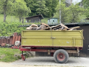 a yellow truck with a pile of wood in the back